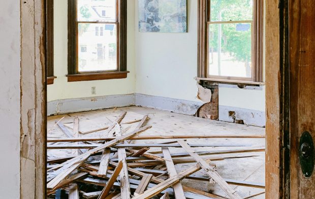 pexels-photo-4756488-4756488 Interior room under renovation with exposed beams and planks piled on the floor.
